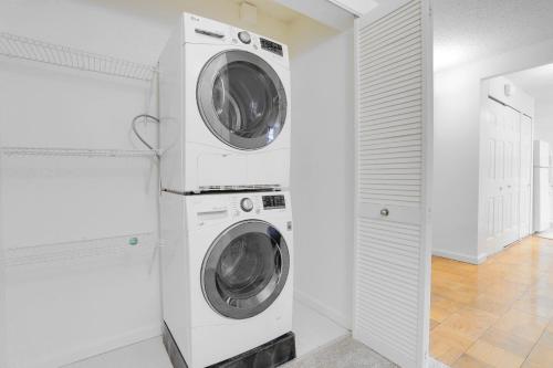 two washing machines in a white laundry room at Apartment Near to Metro Station at Crystal city in Arlington