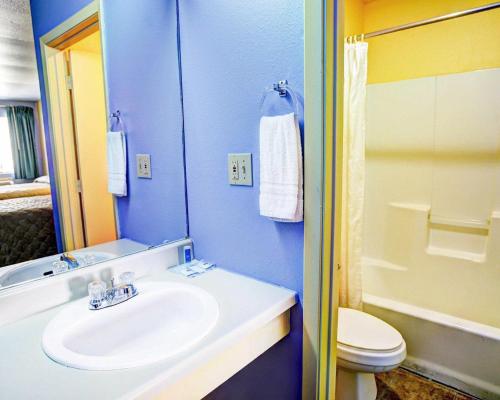a blue bathroom with a sink and a toilet at Nites Inn in Killeen