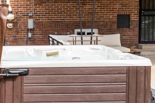 una vasca da bagno posta di fronte a un edificio in mattoni di 5280 Oasis - Hot Tub Walk To Sloan's Lake a Denver