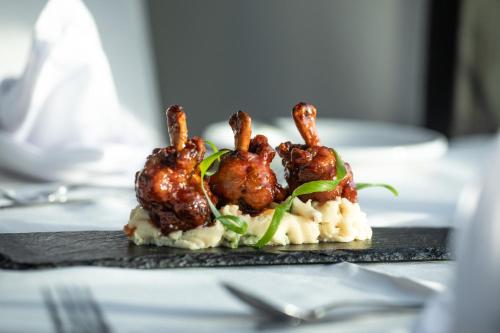 a plate of food with shrimp on top of mashed potatoes at Comfort Inn & Suites Tobago in Tobago Island