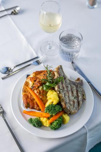 a plate of food with meat and vegetables on a table at Comfort Inn & Suites Tobago in Tobago Island