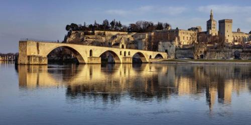 a bridge over a river with a city in the background at Le temps de vivre in Mormoiron