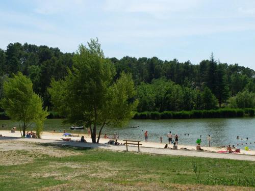 a group of people on a beach near a lake at Le temps de vivre in Mormoiron