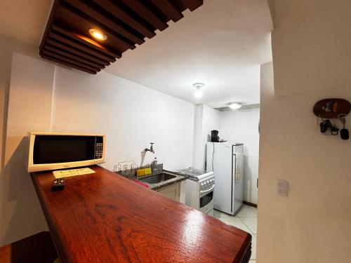 a kitchen with a counter top with a television on it at Refúgio de Guarapari in Guarapari