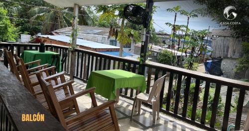 a balcony with chairs and a green table on it at Hotel Casa Costa in Capurganá