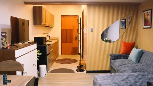 a living room with a couch and a kitchen at Loft2600 in Baguio