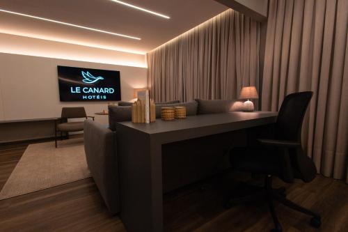 a office with a desk and a television in a room at Hotel Le Canard Lages in Lages