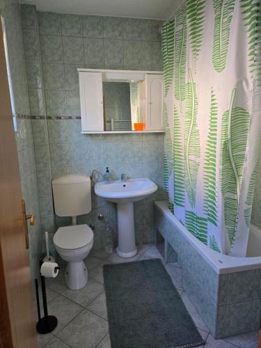 a bathroom with a sink and a toilet and a shower at Urban Home Visoko in Visoko