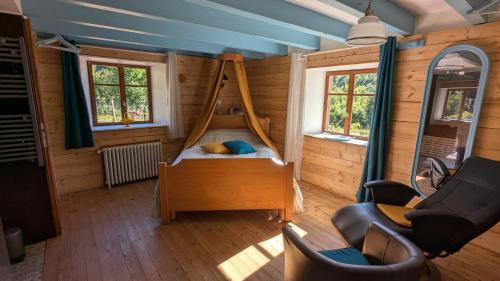 ein Schlafzimmer mit einem Bett in einem Zimmer mit Holzwänden in der Unterkunft Le Chalet Vosges Montagne in Le Tholy