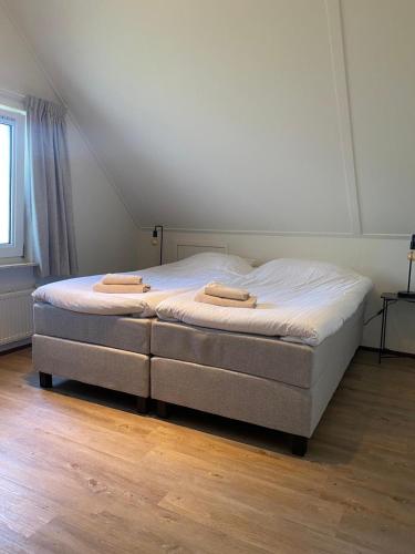 a bedroom with a bed with two towels on it at Landhuis Sint Nyk in Sint Nicolaasga