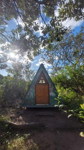 a small house with a door in a forest at Tiny Room in Passagem