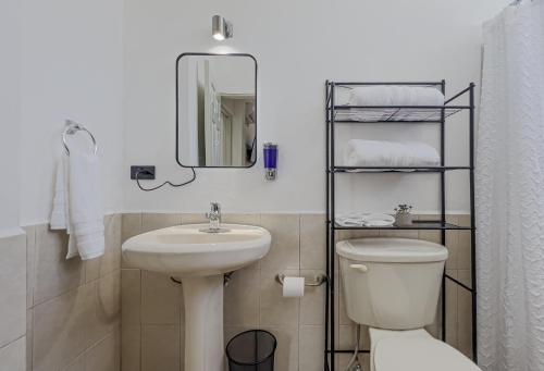 une salle de bains avec lavabo, toilettes et miroir dans l'établissement Casa Balandra 2BR home downtown LPZ walk everywhere, à La Paz