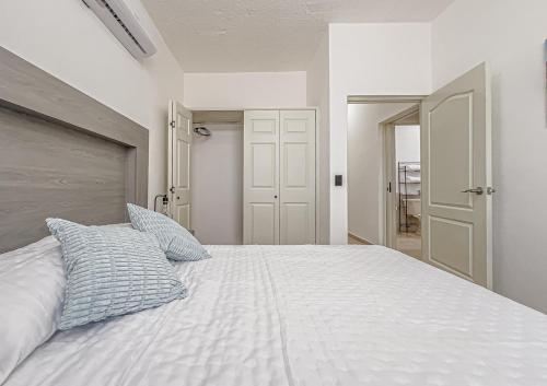 une chambre avec un lit blanc avec deux oreillers dans l'établissement Casa Balandra 2BR home downtown LPZ walk everywhere, à La Paz