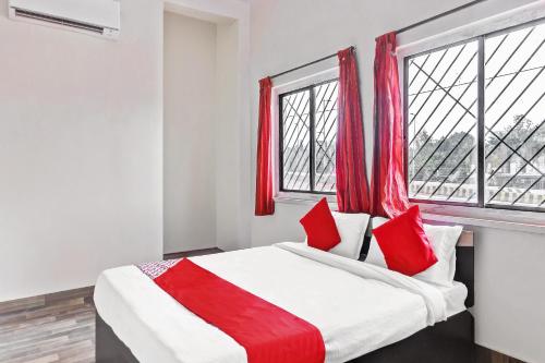 ChikalthānにあるHotel O Shree Balaji Lodgingのベッドルーム1室(赤いカーテン付きの大型ベッド1台付)