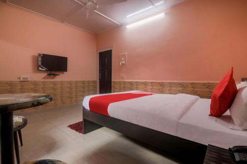 a bedroom with a bed and a flat screen tv at Collection O Trinayan Associates in Dibrugarh