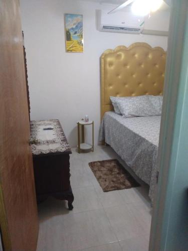 a small bedroom with a bed and a table at Ensom Escape in Spanish Town