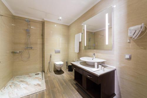 y baño con lavabo, ducha y aseo. en Shera Inn Hotel, en Almaty