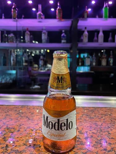 a bottle of molico sitting on a table in a bar at Hotel Hacienda Real in Ciudad del Carmen
