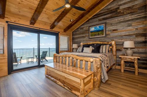 ein Schlafzimmer mit einem Bett und einem großen Fenster in der Unterkunft Skyfall Lodge by American Patriot Getaways in Park Settlement