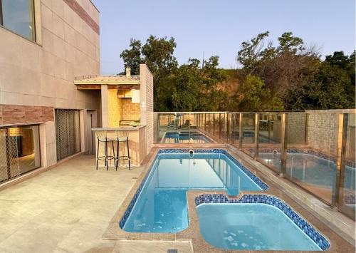 a swimming pool on the patio of a house at Luxo Frente Mar em 7 Qtos com Ar sendo 4 suites para até 18 pessoas, 2 Jacuzzi Aquecidas, piscina, brinquedoteca, 5min de Castelhanos in Anchieta