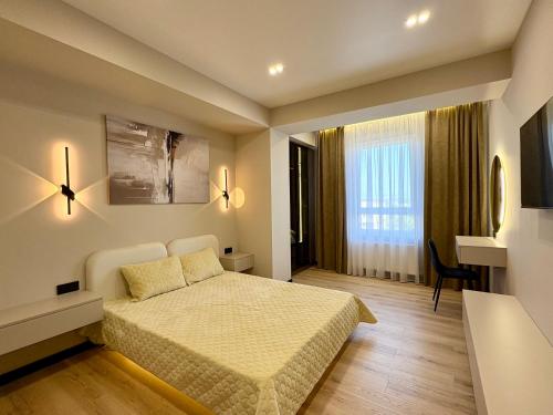 een slaapkamer met een bed, een bureau en een raam bij Avenue Boutique Luxury N4 in Chişinău