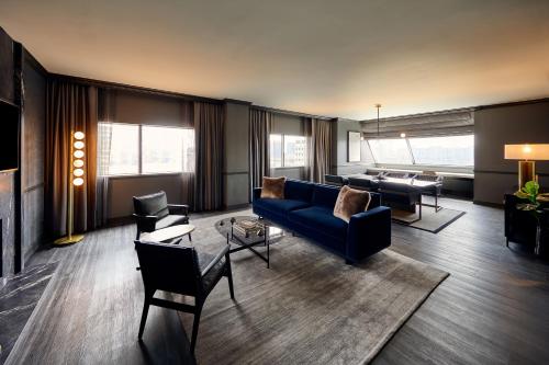 a living room with a blue couch and chairs at Loews Nashville Hotel at Vanderbilt Plaza in Nashville