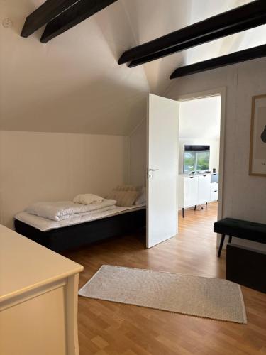 Habitación con cama y puerta a un dormitorio en Hvidbo, en Vordingborg