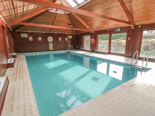 a large swimming pool in a building with a ceiling at Whitby Cottage and Pool - Cinder Track Walks in Whitby