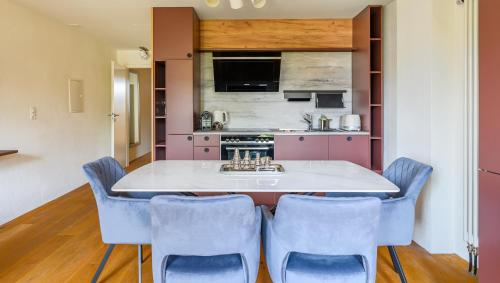 een keuken met een kookeiland met spoelbak en blauwe stoelen bij Casa Rheinblick - Apartment C in Bazel