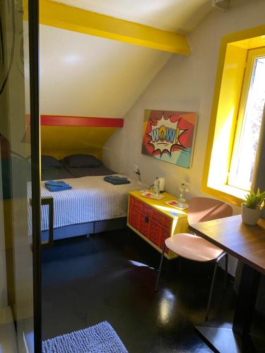 a small bedroom with a bed and a table and chairs at Perk25A in Steenokkerzeel