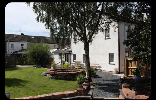 a house with a tree and a bench in a yard at Foundry View in Millom