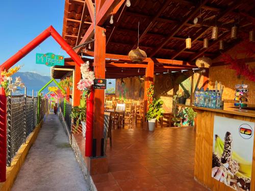 a building with a bar and a restaurant with flowers at Alojamiento el Abuelo in San Pedro La Laguna
