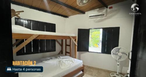 a bedroom with two bunk beds and a window at Hotel Casa Costa in Capurganá