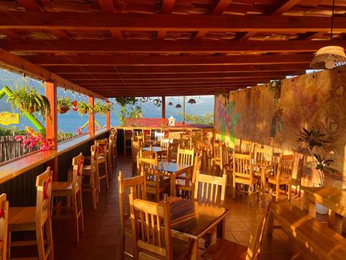 a restaurant with wooden tables and chairs and windows at Alojamiento el Abuelo in San Pedro La Laguna