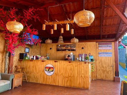 a bar in a restaurant with a man behind the counter at Alojamiento el Abuelo in San Pedro La Laguna