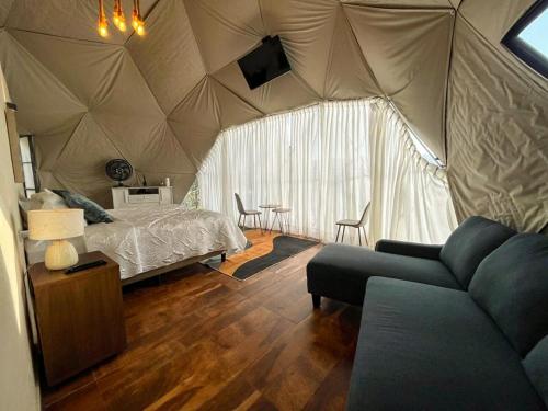 a bedroom with a tent with a bed and a couch at Sweet Forest-Domo Sol in Sanabria