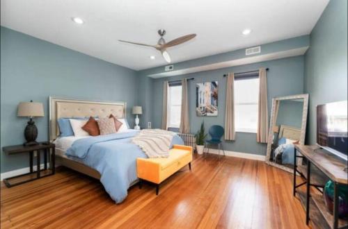 a bedroom with blue walls and a bed and a television at Chic 5 BD home in Little Italy in Baltimore