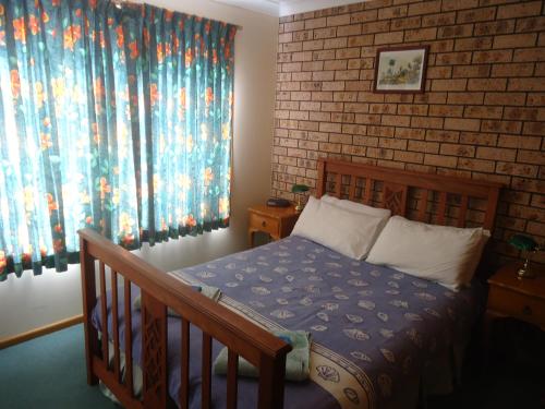 a bedroom with a bed and a brick wall at Dalmeny Shores in Dalmeny