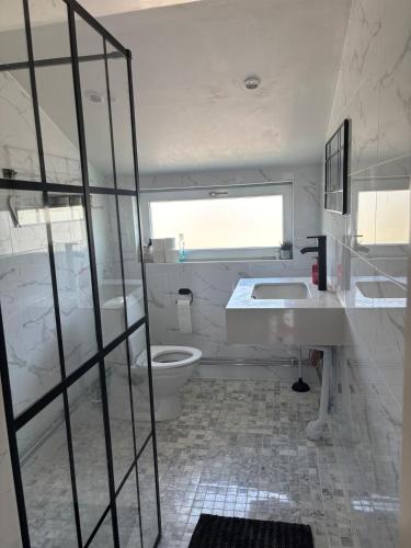 a white bathroom with a toilet and a sink at Villa Fredsstigen in Åmål