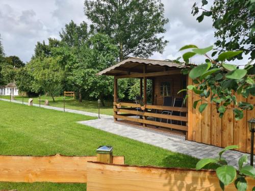 a wooden gazebo in a park at Das Reethaus - Midgard in Tolk