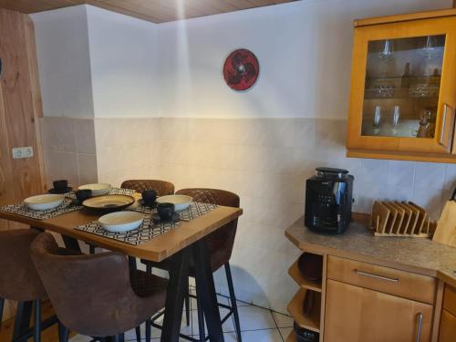 a kitchen with a table with chairs and a coffee maker at Das Reethaus - Midgard in Tolk