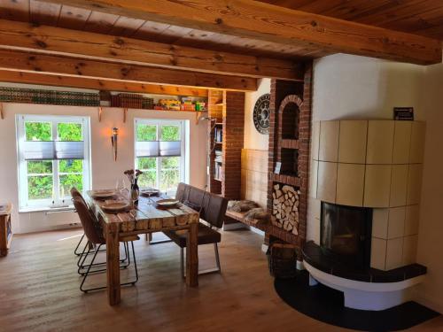 a living room with a table and a fireplace at Das Reethaus - Midgard in Tolk