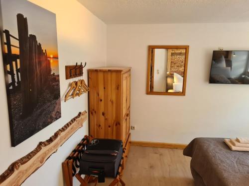 a bedroom with a bed and a mirror at Das Reethaus - Midgard in Tolk