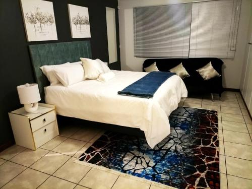 a bedroom with a bed with a blue blanket on it at Gracious Beauty in Bloemfontein