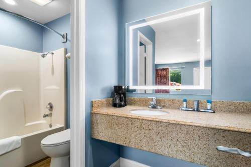 a bathroom with a sink and a mirror at Americas Best Value Inn and Suites Siloam Springs in Siloam Springs