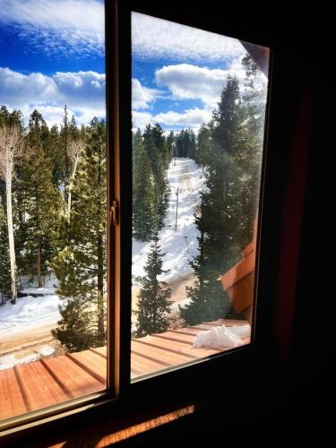 a window with a view of a snow covered mountain at Three level cabin with Hot Tub in Duck Creek Village