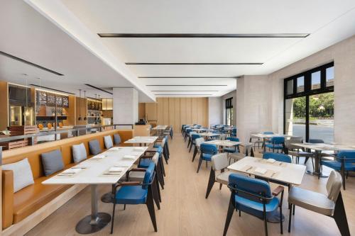 a dining room with tables and blue chairs at Fairfield by Marriott Yining in Yining
