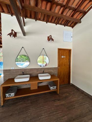 a room with two sinks and two mirrors on the wall at Chácara em Piracaia in Piracaia