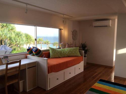 um quarto com uma cama e uma grande janela em The Villa Kazbo em Amami