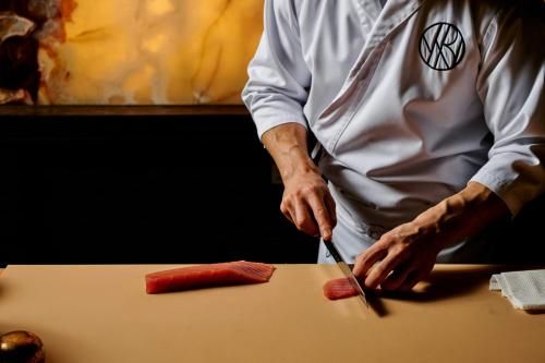 a chef cutting up a carrot on a table at W Melbourne in Melbourne